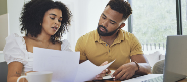 Image of a couple looking at paperwork within their home.